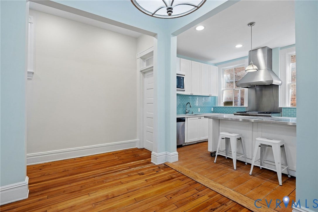 5 S Adams Street, Richmond, VA 23220 Kitchen with light wood finished floors, a breakfast bar area, light countertops, pendant lighting, and extractor fan