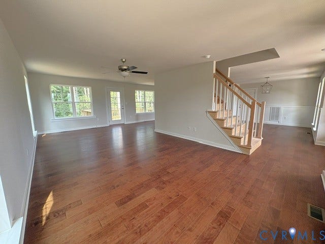 162 Bacon Bit Ln, Louisa, VA 23093 Expansive room featuring wood-finish flooring, numerous windows, a ceiling fan, and a wood staircase with white risers