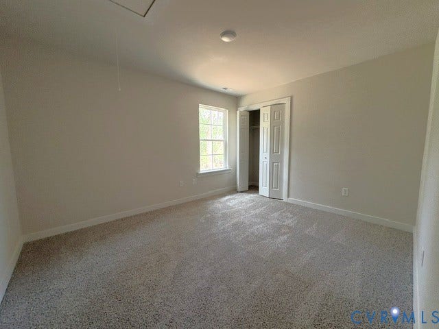 162 Bacon Bit Ln, Louisa, VA 23093 Wall-to-wall carpet flooring, window with white trim, bi-fold closet doors, ceiling-mounted light fixture, and attic access panel