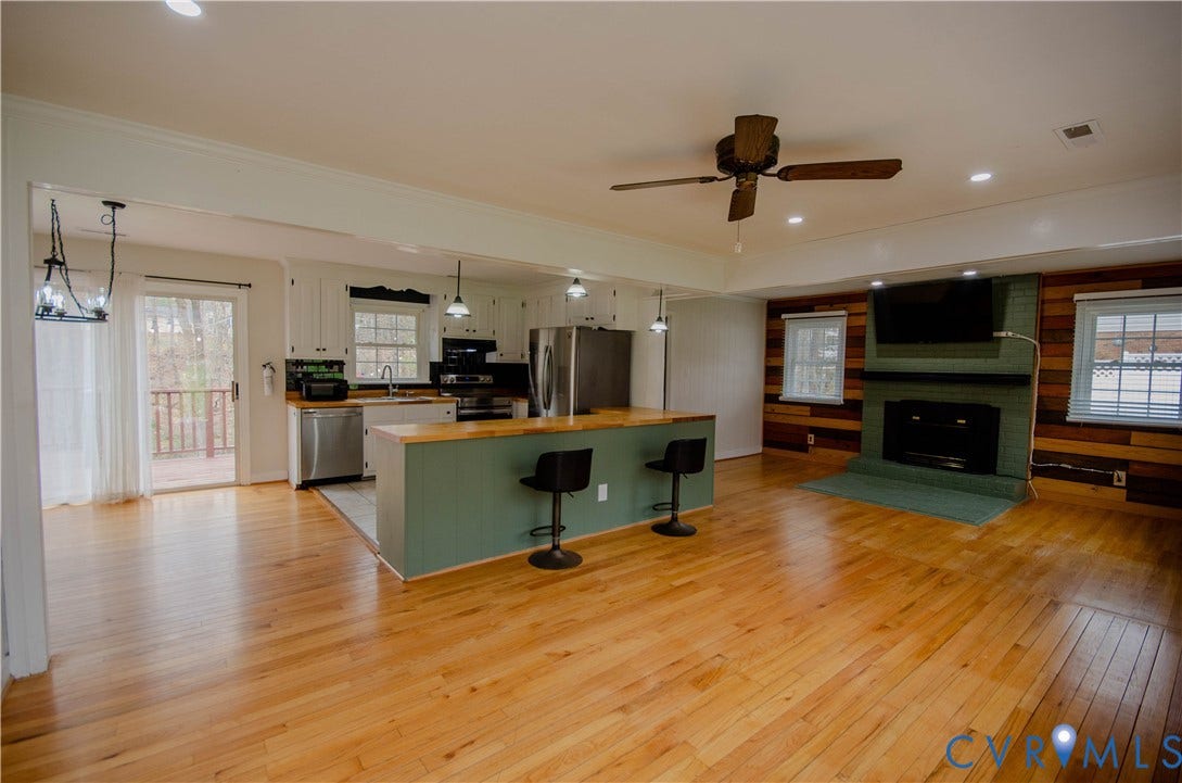 2231 Fall Line Drive, Powhatan, VA 23139 Kitchen with wood counters, light wood-style floors, stainless steel appliances, a kitchen bar, and a center island