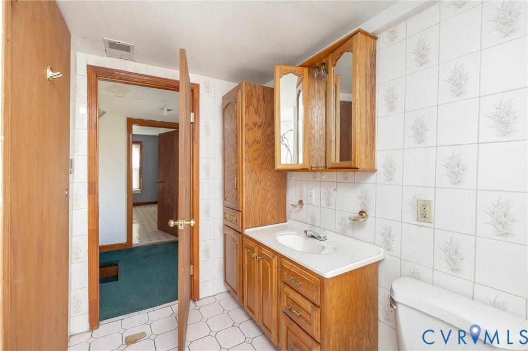 2606 Cedar Street, Richmond, VA 23223 Half bath featuring tile walls, vanity, and light tile patterned flooring