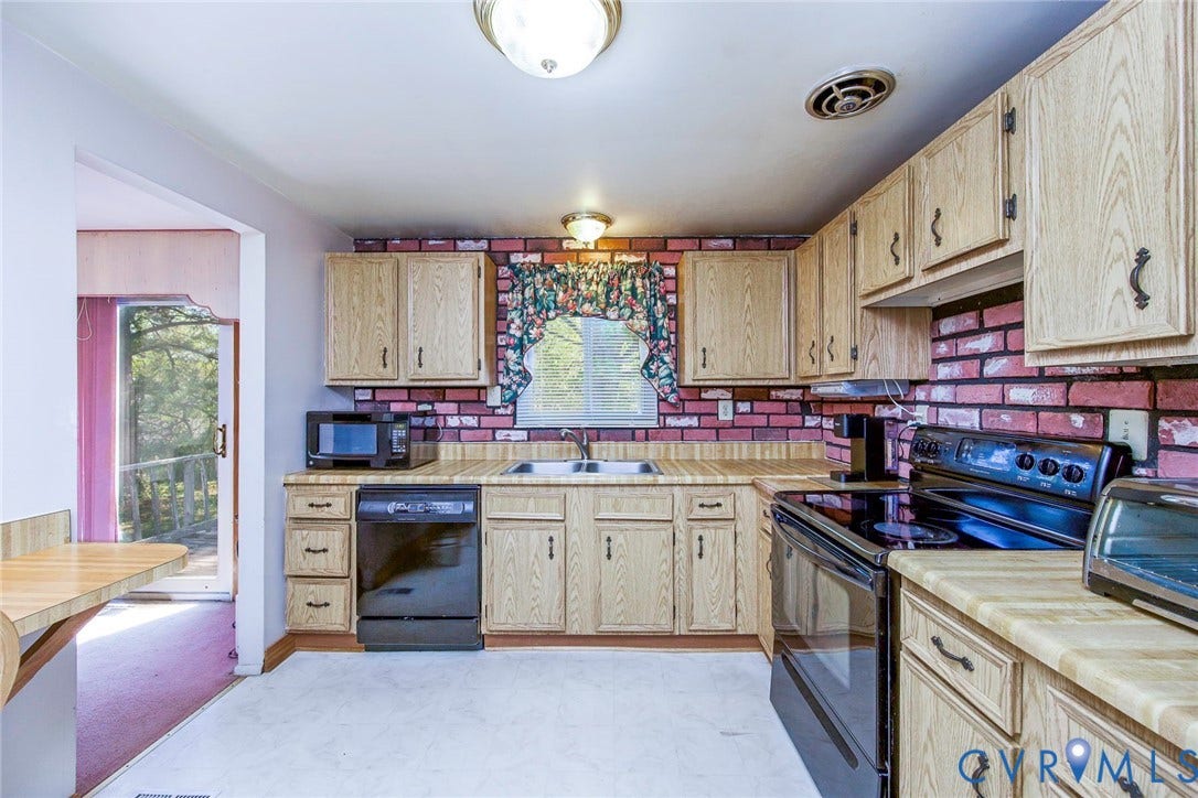 The kitchen features wood grain cabinetry, a brick-patterned backsplash, and durable laminate countertops
