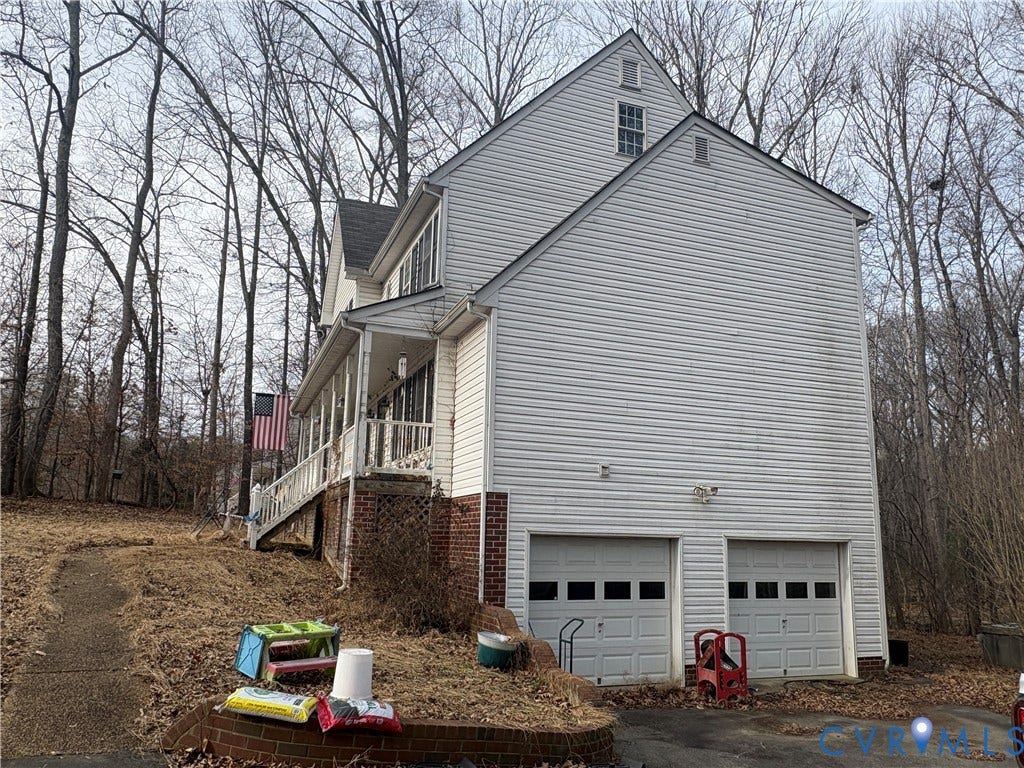 3216 Sherwood Bluff Terrace, Powhatan, VA 23139 View of side of home featuring a garage, a porch, and asphalt driveway