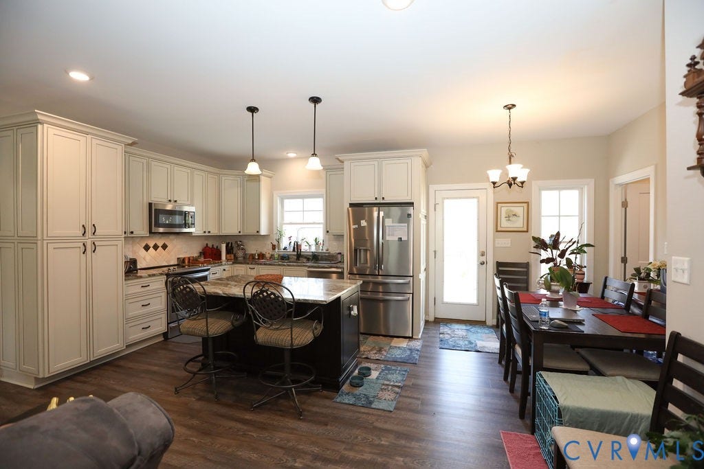 5670 Hickory Street, Powhatan, VA 23139 Kitchen featuring stainless steel appliances, dark wood-type flooring, a center island, a breakfast bar, and suspended lighting