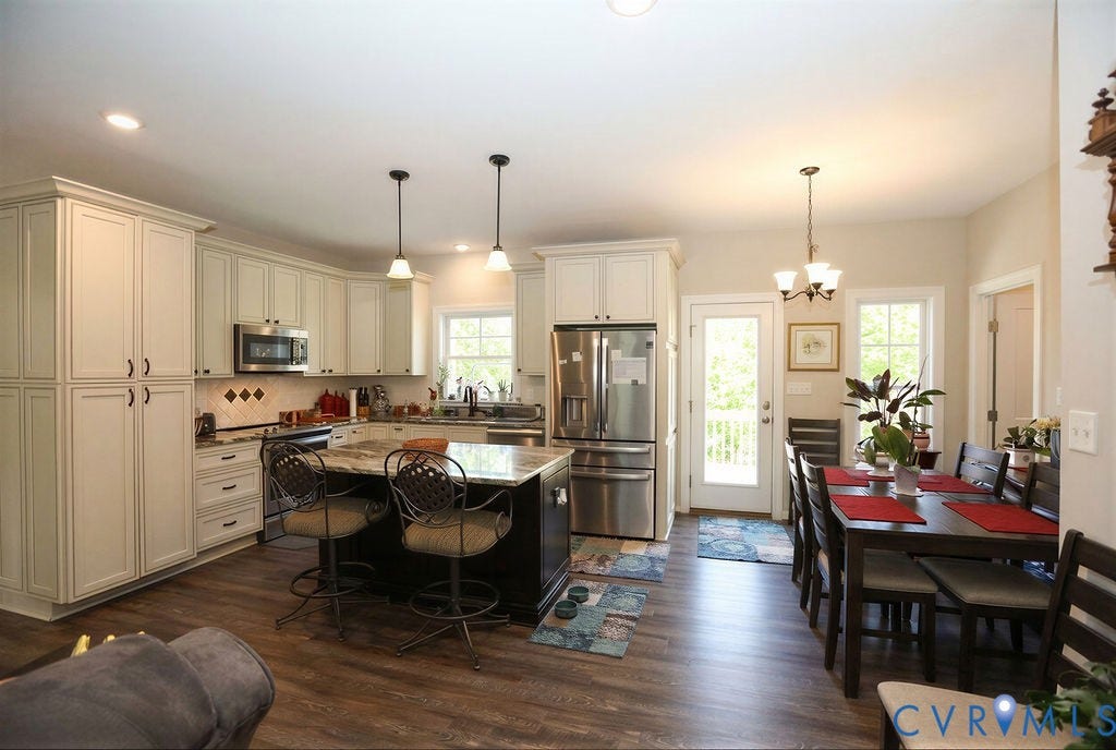 5670 Hickory Street, Powhatan, VA 23139 Kitchen featuring stainless steel appliances, dark wood-type flooring, a kitchen bar, a kitchen island, and dual tone cabinetry