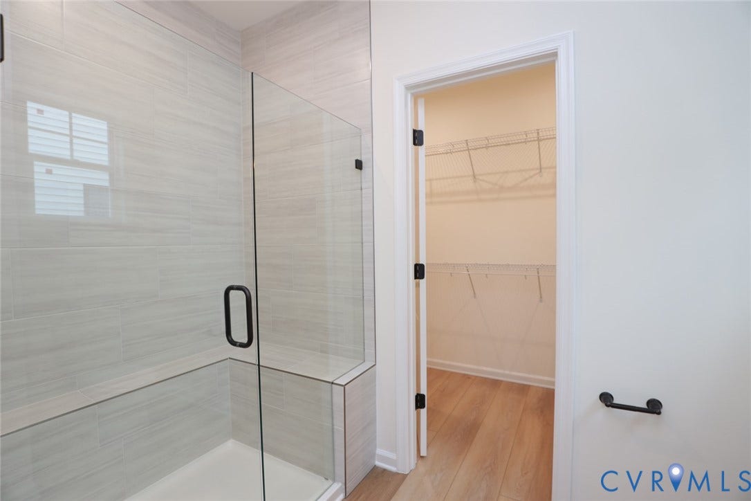 6305 Lila Crest Lane, Cottages At Millwood, Chesterfield, VA 23112 The photo represents the plan, not the actual home. Design selections may vary. The first-floor primary suite offers a spacious walk-in closet and an ensuite bath with a double vanity, soaking tub, and linen closet.