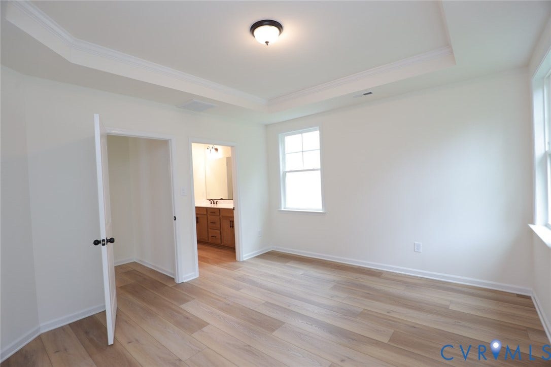 6305 Lila Crest Lane, Cottages At Millwood, Chesterfield, VA 23112 The photo represents the plan, not the actual home. Design selections may vary. The first-floor primary suite offers a spacious walk-in closet and an ensuite bath with a double vanity, soaking tub, and linen closet.