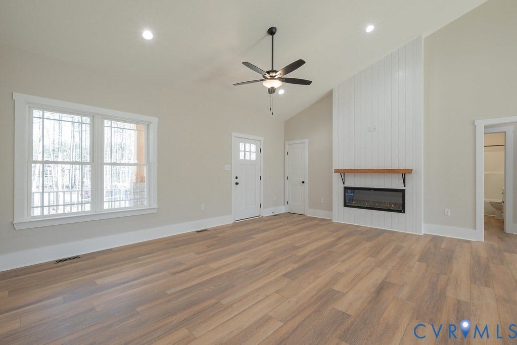 TBD Black Haw Lane, Hanover, VA 23059 Unfurnished living room featuring vaulted ceiling, light wood finished floors, a ceiling fan, a large fireplace, and recessed lighting