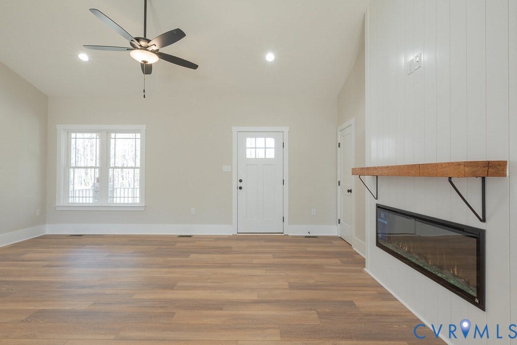 TBD Black Haw Lane, Hanover, VA 23059 Foyer entrance with a glass covered fireplace, dark wood-style flooring, a ceiling fan, wooden walls, and vaulted ceiling