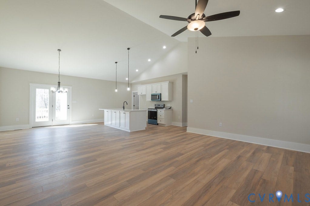 TBD Black Haw Lane, Hanover, VA 23059 Unfurnished living room featuring light wood-type flooring, a chandelier, lofted ceiling, and a ceiling fan