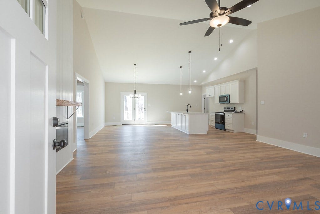 TBD Black Haw Lane, Hanover, VA 23059 Unfurnished living room featuring light wood-style floors, a chandelier, vaulted ceiling, and a ceiling fan