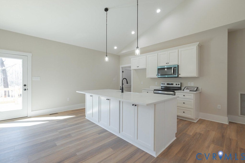 TBD Black Haw Lane, Hanover, VA 23059 Kitchen with white cabinetry, vaulted ceiling, a center island with sink, stainless steel appliances, and light wood-style flooring