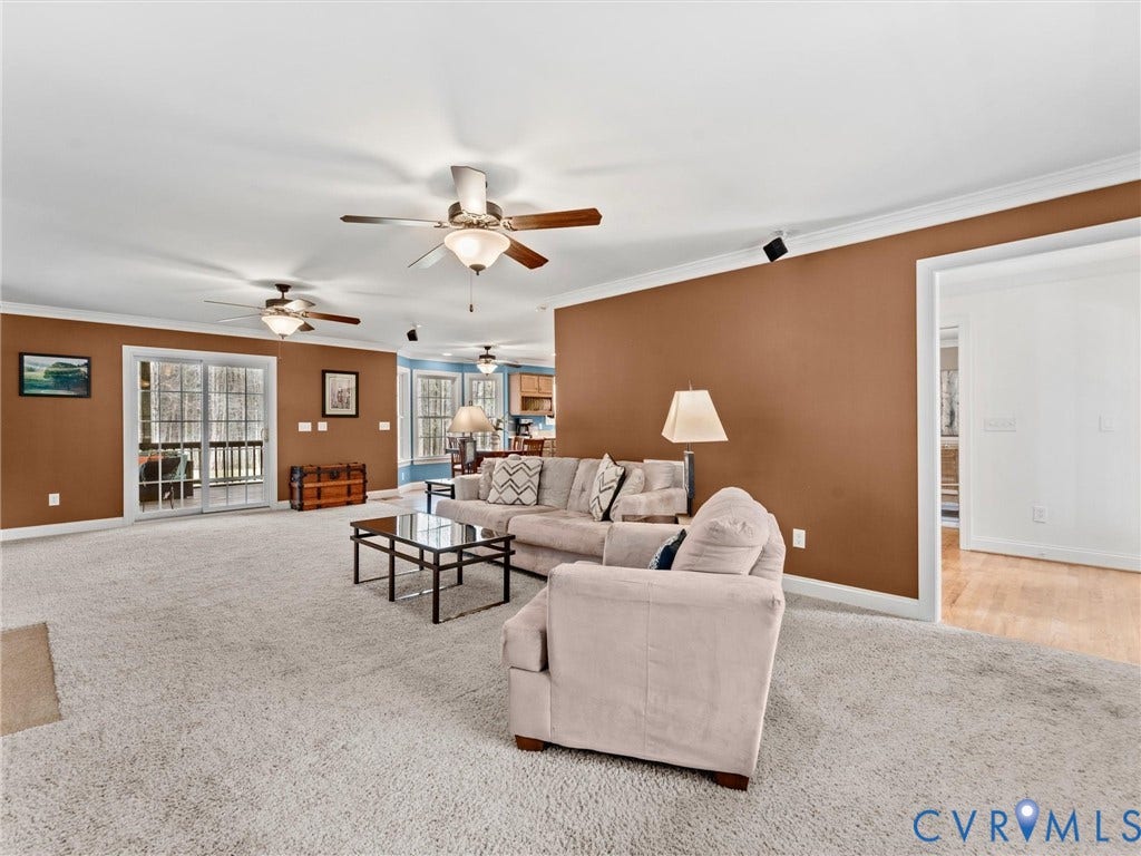 110 Oak Knoll Place, Bumpass, VA 23024 Carpeted living space with ceiling fans, gas fireplace, surround sound, and access to screened porch