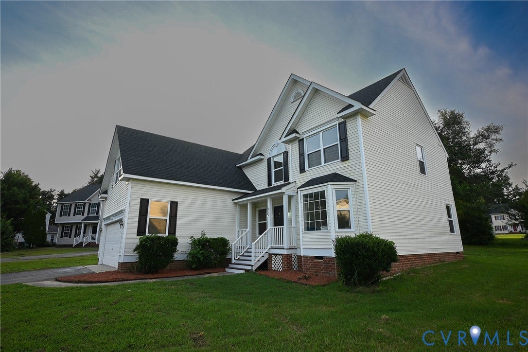 912 Harmony Road, Fairfield, VA 23059 Two-story residence featuring light-colored siding, contrasting dark shutters, and a bay window