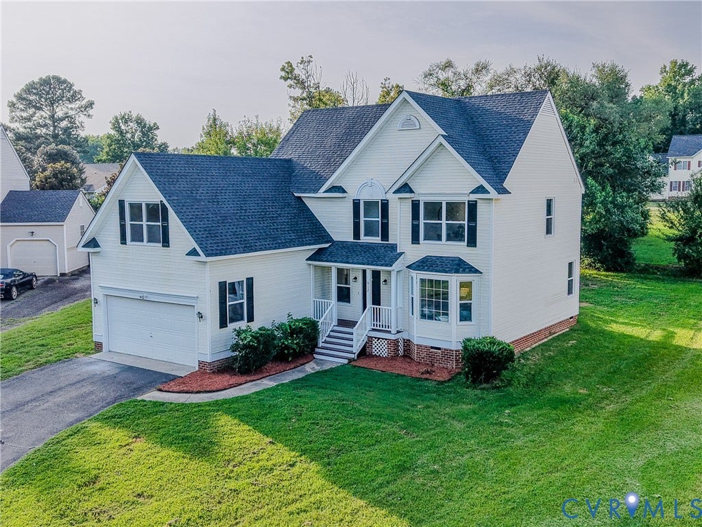 912 Harmony Road, Fairfield, VA 23059 Classic two-story Colonial featuring a crisp white exterior with dark blue architectural shingles, multiple gabled rooflines, and brick foundation detailing