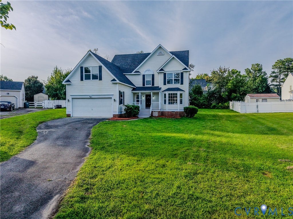 912 Harmony Road, Fairfield, VA 23059 Colonial-style residence featuring a two-car attached garage, brick and siding exterior, multi-gable roofline with architectural detail, and a manicured front lawn with mature landscaping