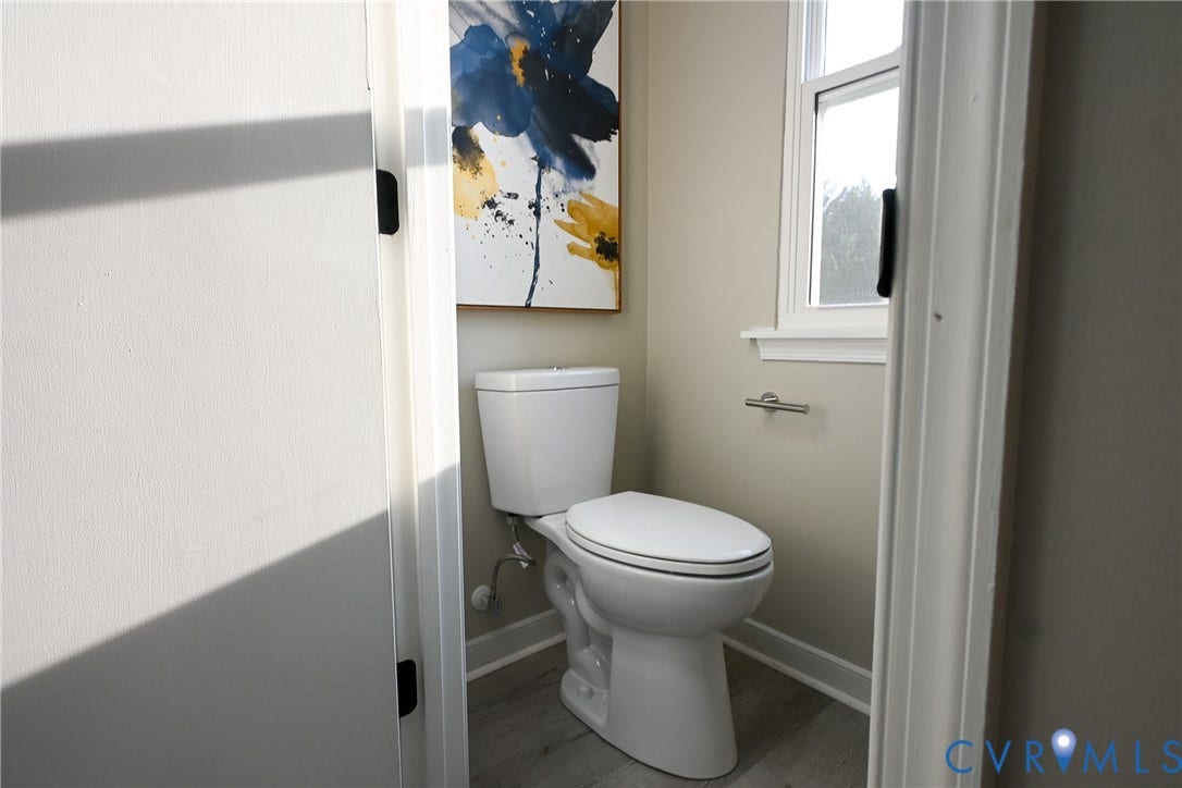 912 Harmony Road, Fairfield, VA 23059 White toilet, light gray walls, wood-finish flooring, white window trim
