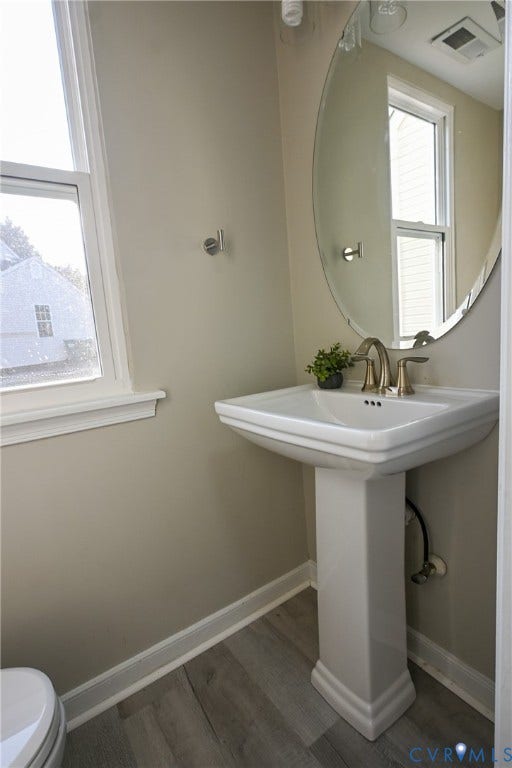 912 Harmony Road, Fairfield, VA 23059 Pedestal sink with brass-finish faucet, oval mirror, and wood-finish flooring