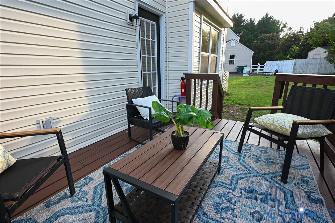 912 Harmony Road, Fairfield, VA 23059 Composite deck with composite wood-finish decking and geometric patterned outdoor rug, furnished with black metal-frame seating