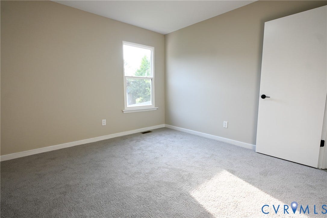 912 Harmony Road, Fairfield, VA 23059 Bright corner bedroom with abundant natural light from dual windows, neutral wall finishes, and neutral carpet flooring