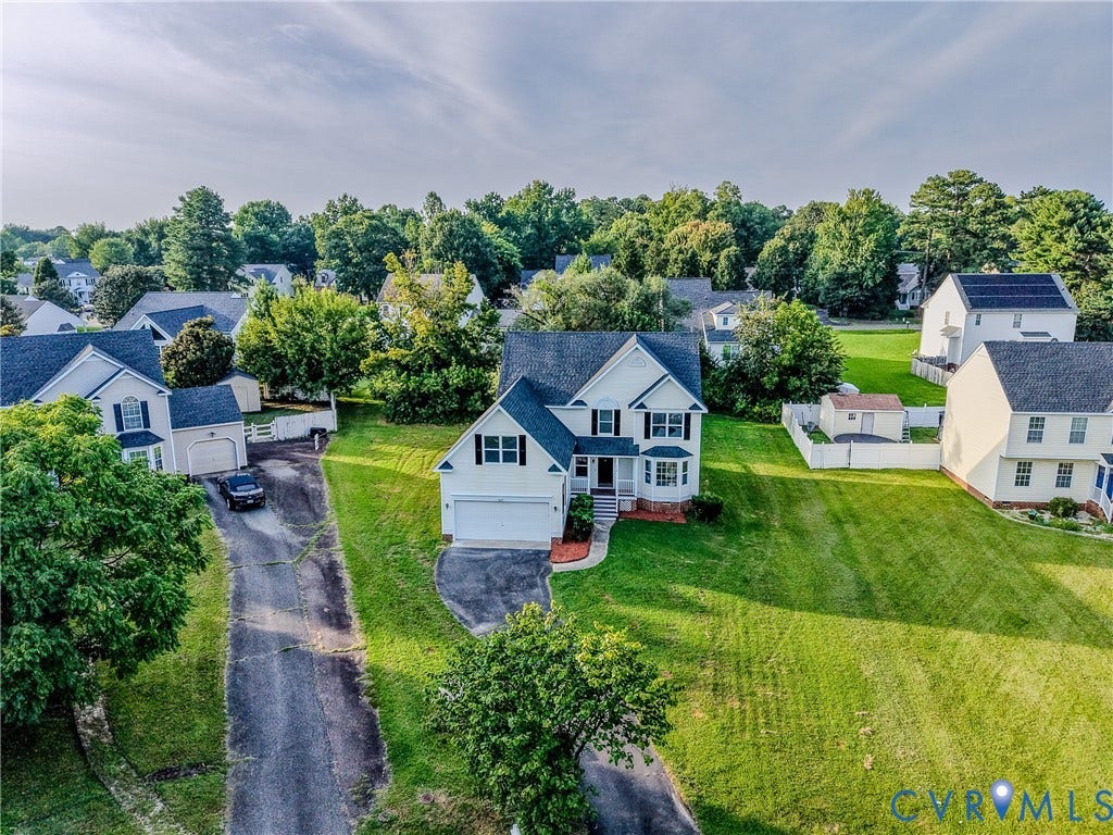 912 Harmony Road, Fairfield, VA 23059 Stately two-story colonial with white exterior and black shutters, featuring a two-car attached garage and circular driveway