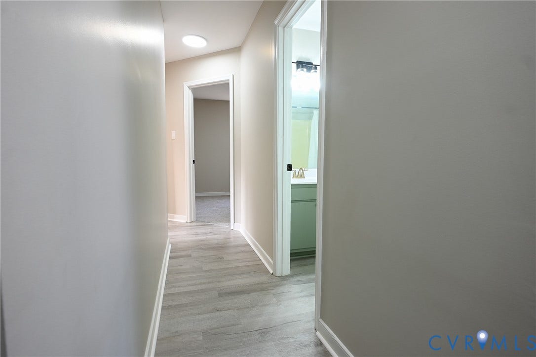 912 Harmony Road, Fairfield, VA 23059 Modern hallway featuring wood-finish flooring, recessed ceiling lighting, and clean white walls with contemporary trim detailing