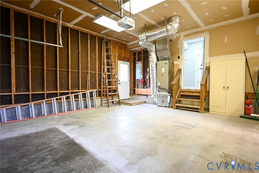 912 Harmony Road, Fairfield, VA 23059 Spacious garage interior with concrete flooring, exposed beam ceiling with recessed lighting, and built-in wall storage cabinetry