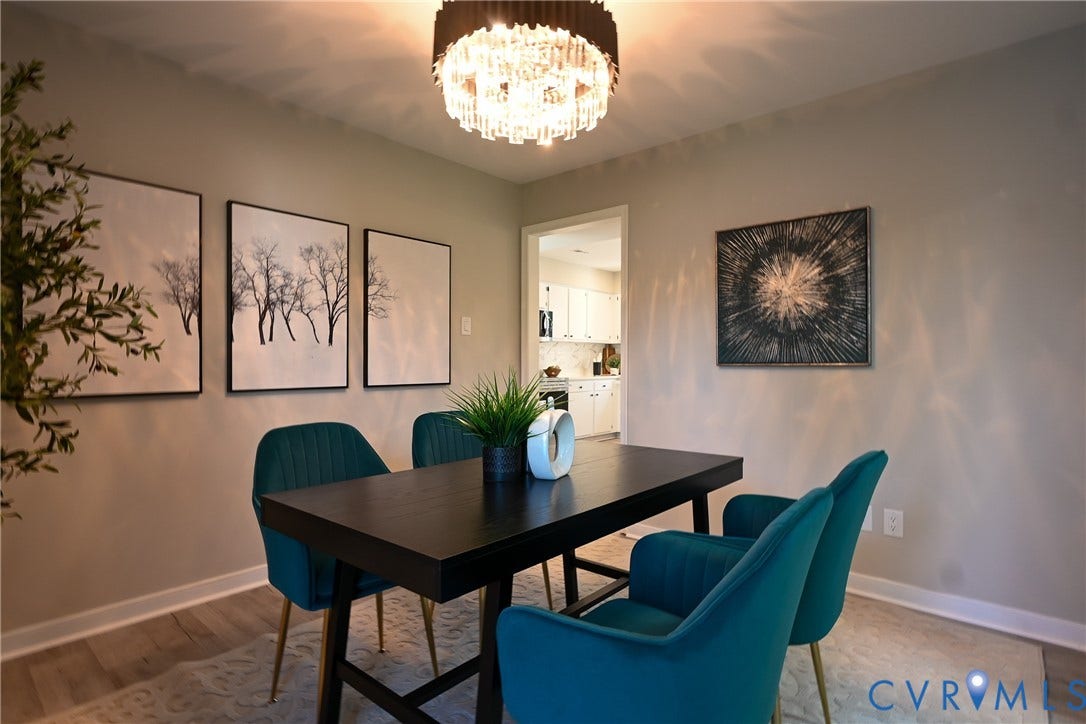 912 Harmony Road, Fairfield, VA 23059 Elegant dining room featuring a black rectangular table, teal upholstered chairs with metal legs, wood-finish flooring, and a modern crystal chandelier
