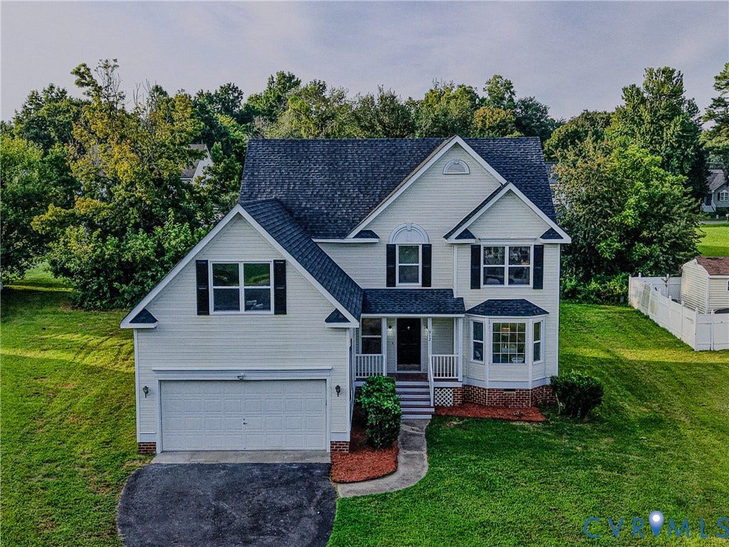 912 Harmony Road, Fairfield, VA 23059 Two-story residence featuring light-colored siding, a dark shingle roof, a two-car garage, and a bay window