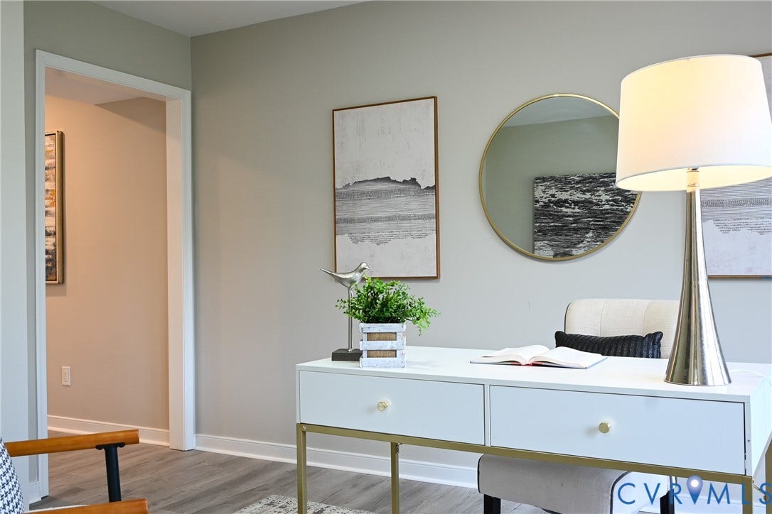 912 Harmony Road, Fairfield, VA 23059 Modern home office featuring a streamlined white desk with brass hardware and metal legs, paired with a sleek metal floor lamp with linen shade