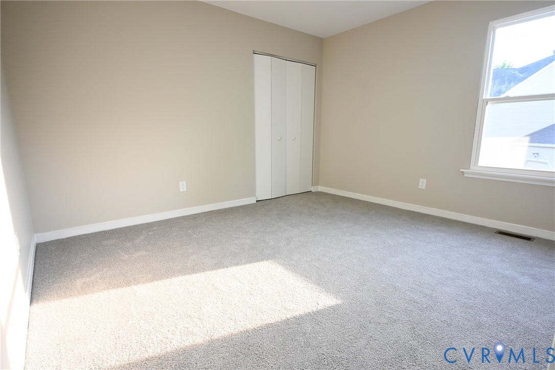912 Harmony Road, Fairfield, VA 23059 Neutral tone wall paint, carpet flooring, bi-fold closet doors, and white trim window