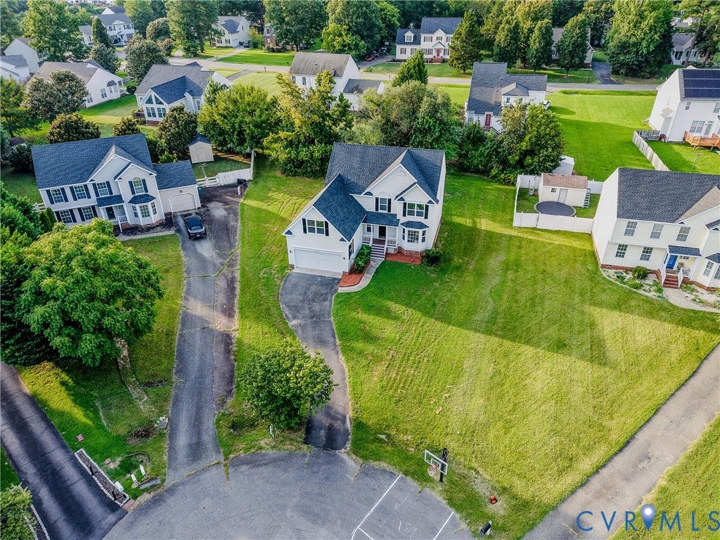 912 Harmony Road, Fairfield, VA 23059 Elegant Colonial residence set on expansive manicured grounds featuring mature landscaping, circular driveway with asphalt surface, and generous lawn acreage
