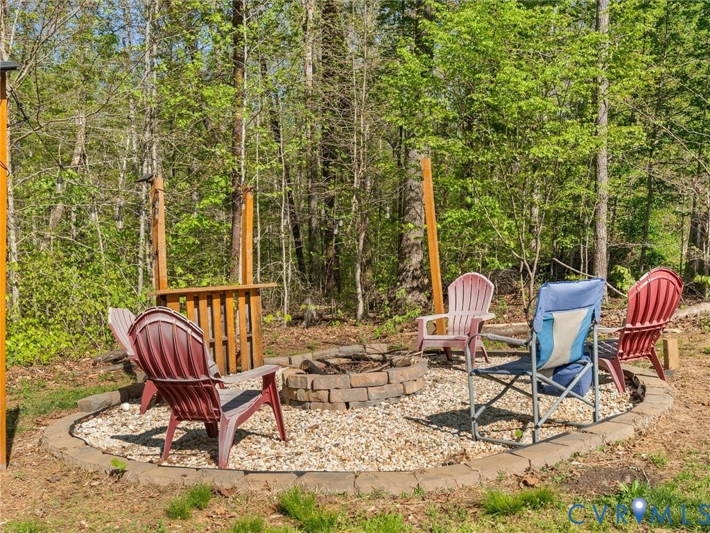 126 Reedy Creek Road, Reedy Creek, Louisa, VA 23093 Outdoor fire pit area with a gravel base and a stone border, surrounded by mature trees