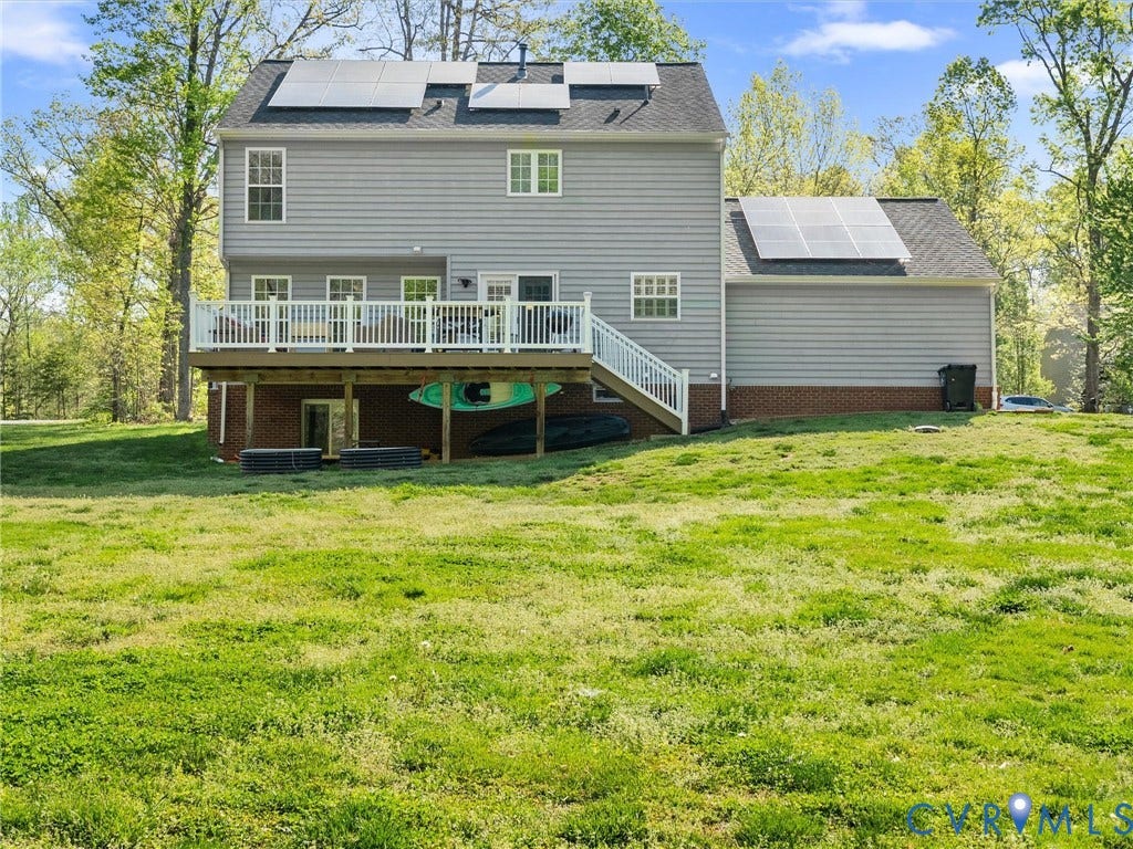 126 Reedy Creek Road, Reedy Creek, Louisa, VA 23093 The property features a spacious deck with white railings, a walk-out basement, and solar panels on the roof