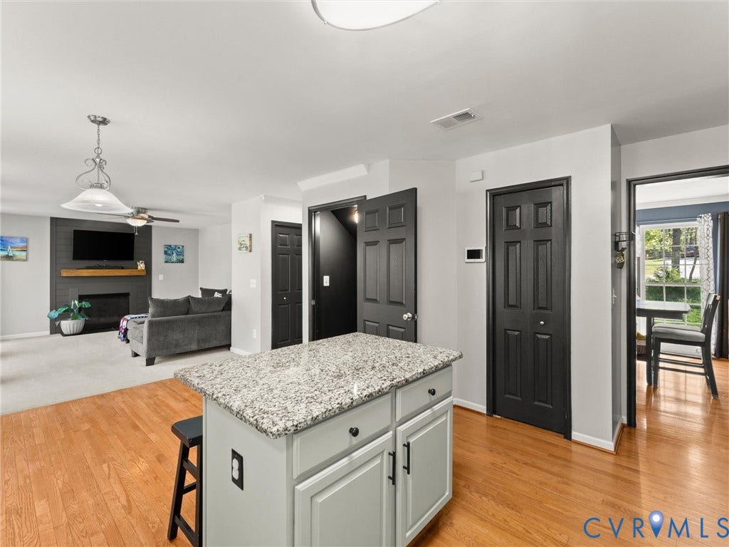 126 Reedy Creek Road, Reedy Creek, Louisa, VA 23093 An open layout connects the kitchen area with a living space featuring a fireplace and ceiling fan