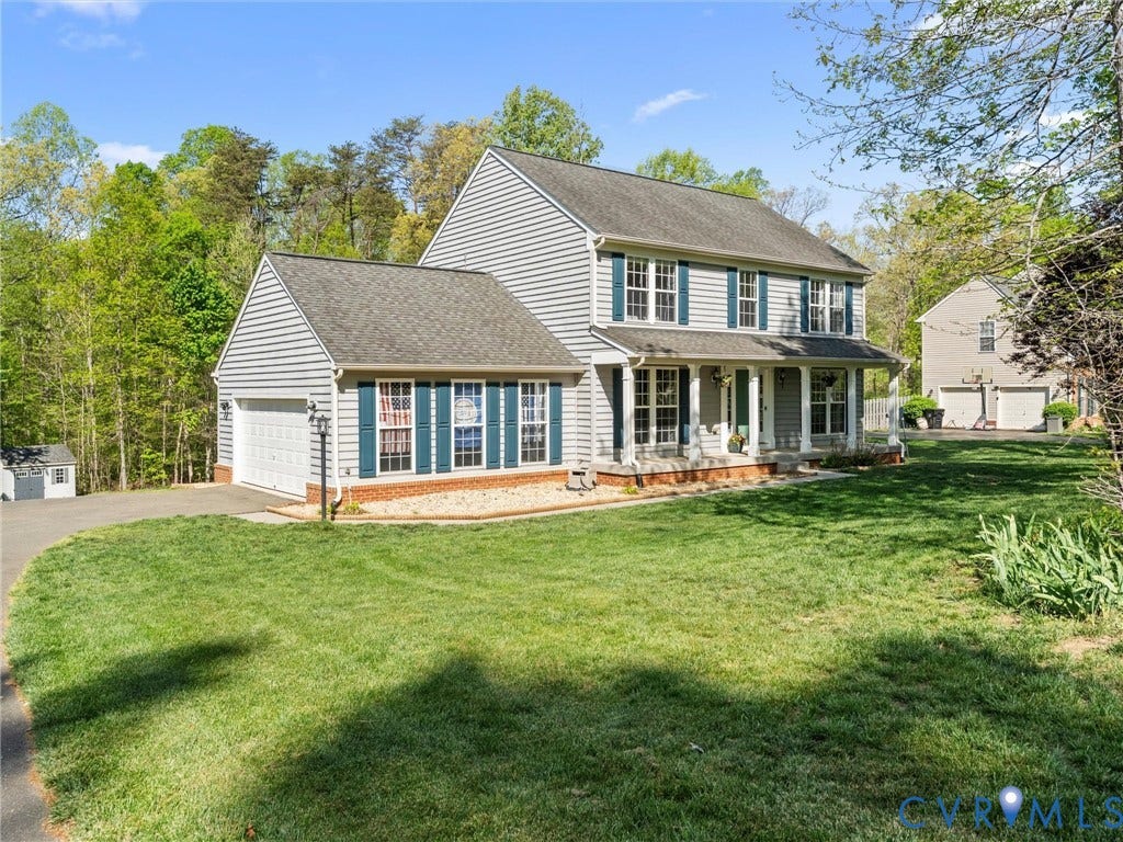 126 Reedy Creek Road, Reedy Creek, Louisa, VA 23093 The property features a two-story exterior with light-colored siding, a covered front porch with white columns, and dark-colored window shutters