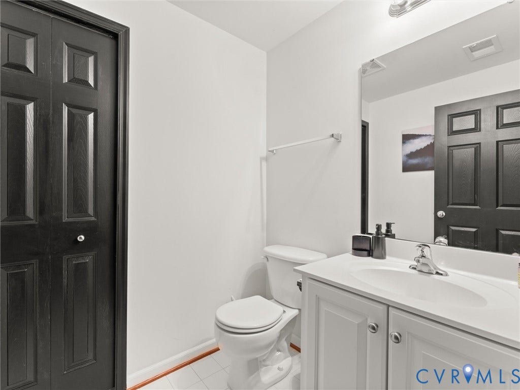 126 Reedy Creek Road, Reedy Creek, Louisa, VA 23093 The bathroom features a white vanity with an integrated sink, a toilet, and a mirror