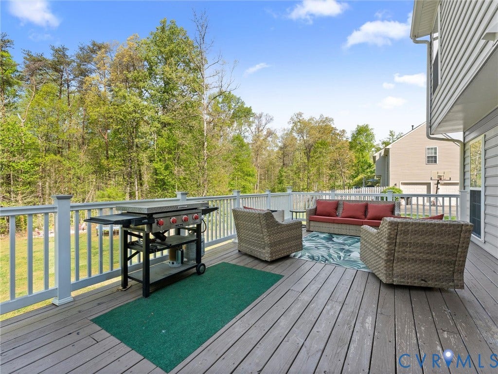 126 Reedy Creek Road, Reedy Creek, Louisa, VA 23093 Expansive outdoor deck with a wooden surface and white railings, offering views of mature trees and open sky