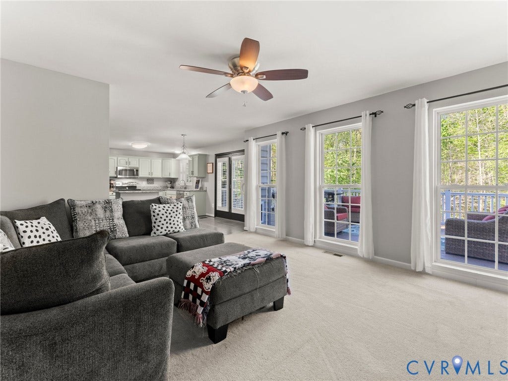 126 Reedy Creek Road, Reedy Creek, Louisa, VA 23093 The living area features light-colored carpeting, a ceiling fan with integrated lighting, and multiple windows providing natural light
