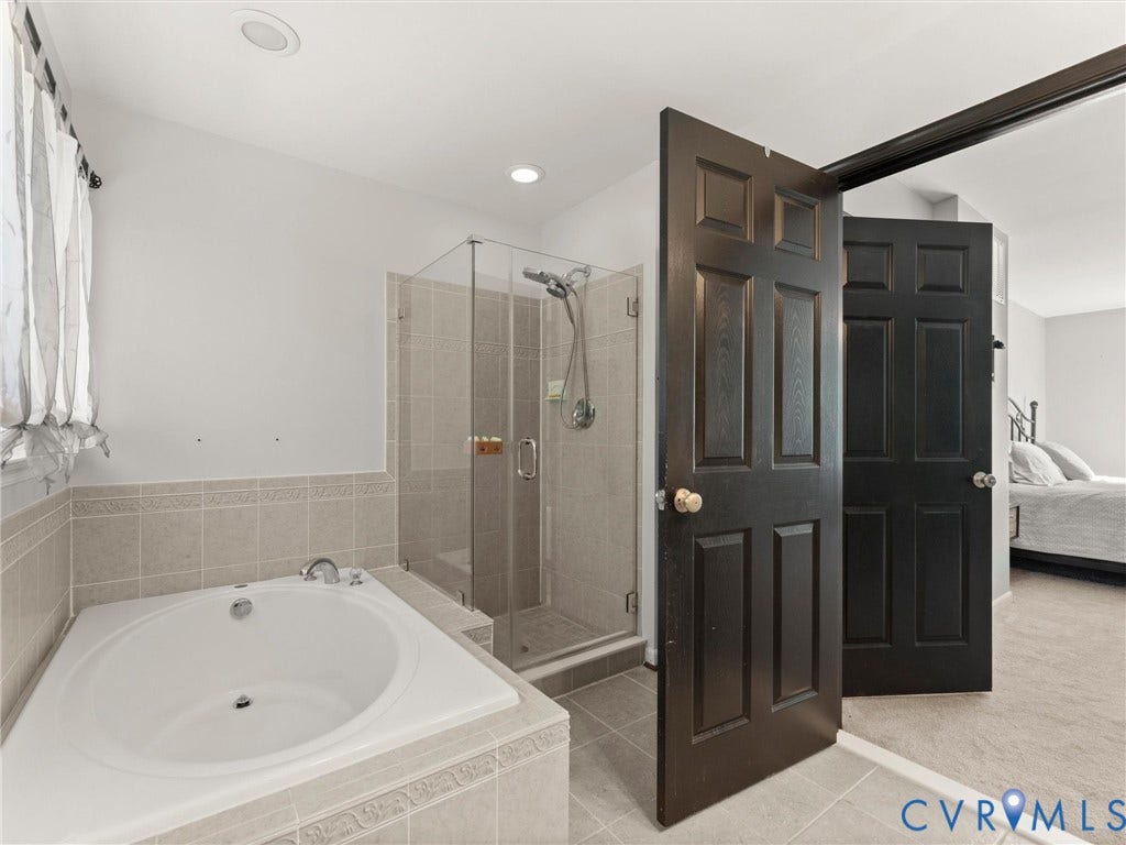 126 Reedy Creek Road, Reedy Creek, Louisa, VA 23093 This bathroom features a spacious built-in tub and a glass-enclosed shower, complemented by tiled walls and flooring