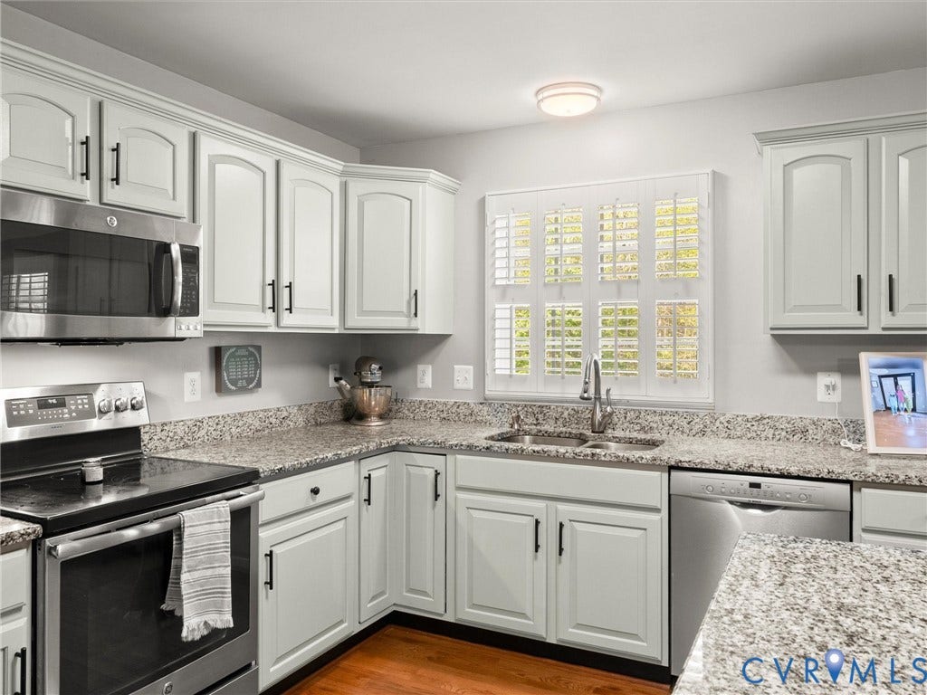 126 Reedy Creek Road, Reedy Creek, Louisa, VA 23093 The kitchen features light-colored cabinetry with dark hardware, granite countertops, and stainless steel appliances including a microwave, range, and dishwasher