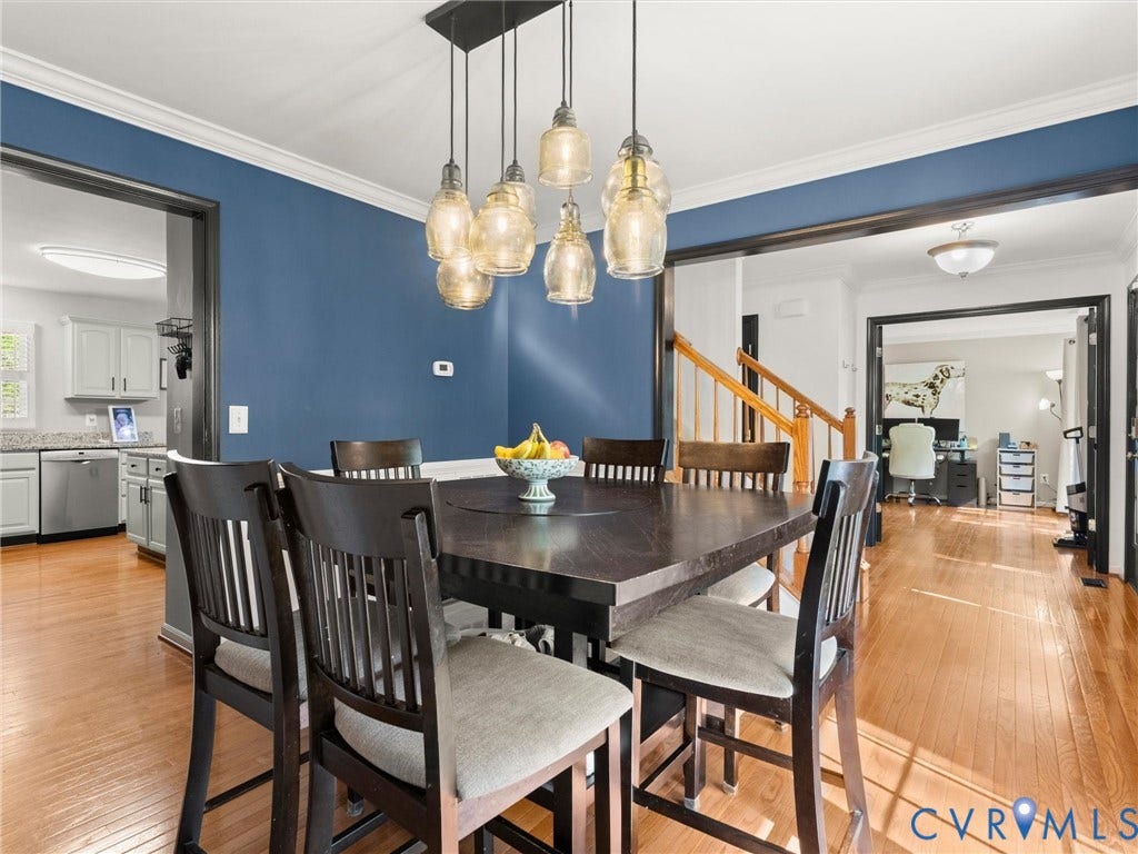 126 Reedy Creek Road, Reedy Creek, Louisa, VA 23093 Dining area featuring hardwood floors, a modern chandelier with multiple pendant lights, and a contrasting blue accent wall