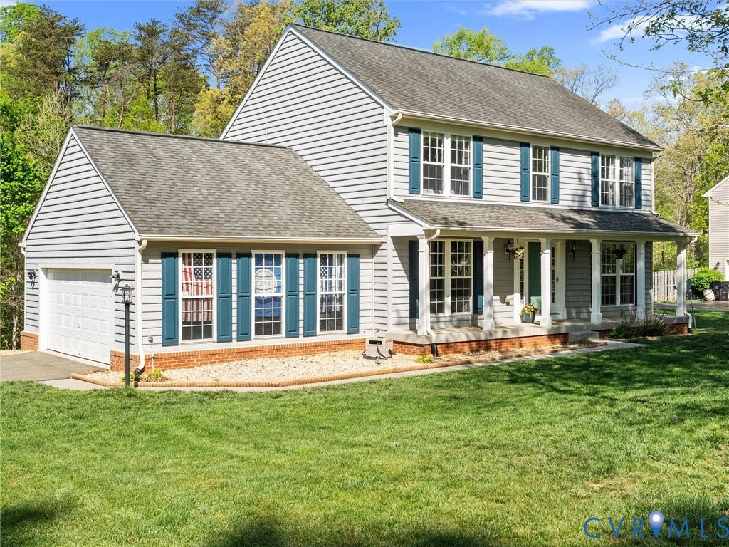 126 Reedy Creek Road, Reedy Creek, Louisa, VA 23093 Exterior view of the property featuring a front lawn, attached garage, covered front porch, and mature trees in the background
