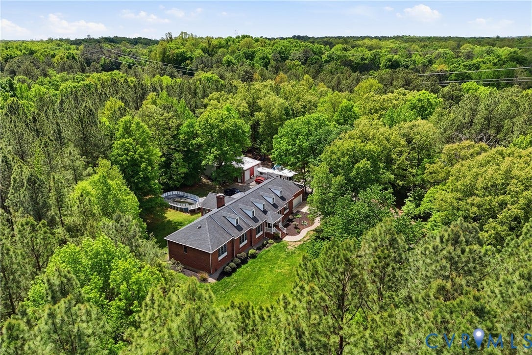 13236 Lea Anna Lane, Hanover, VA 23102 Brick ranch home surrounded by mature trees, featuring a dark shingle roof with multiple dormer windows
