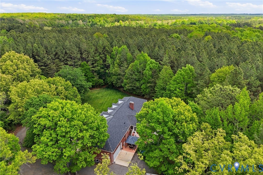 13236 Lea Anna Lane, Hanover, VA 23102 Expansive property featuring a red brick exterior, a dark shingle roof, and a verdant treeline