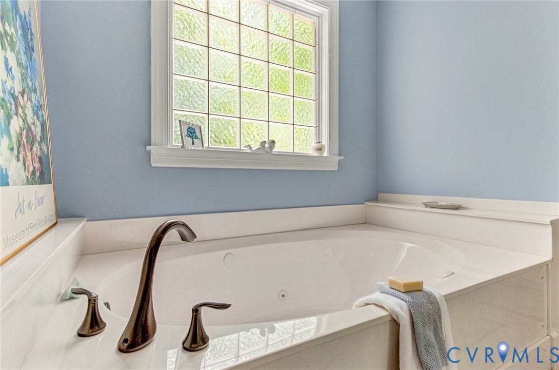 3131 Shadow Creek Drive, Powhatan, VA 23139 Built-in soaking tub featuring bronze-finish fixtures, a white window frame, and a textured privacy window