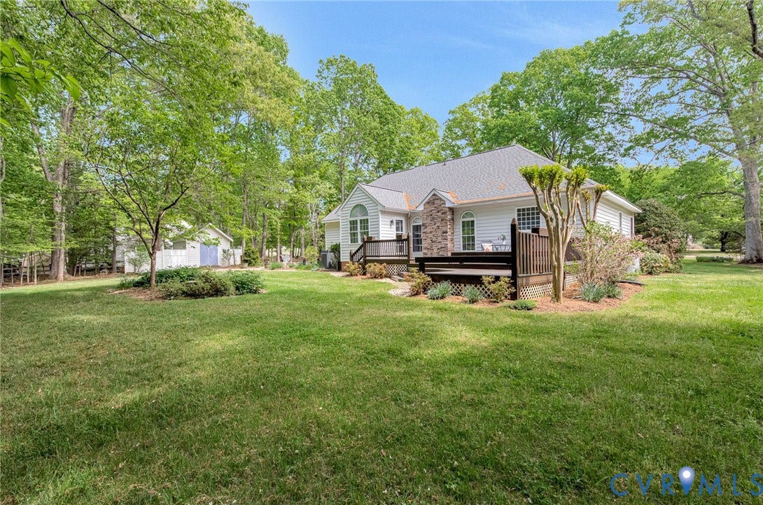 3131 Shadow Creek Drive, Powhatan, VA 23139 Spacious backyard with a sprawling lawn, mature trees, and a multi-level wood-finish deck
