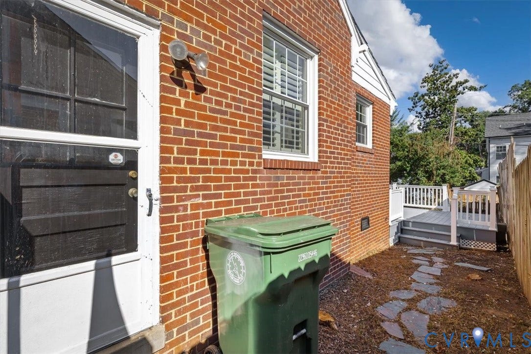 613 Maple Avenue, Near West End, Richmond, VA 23226 Brick exterior featuring white trim windows with interior shutters and a screened door