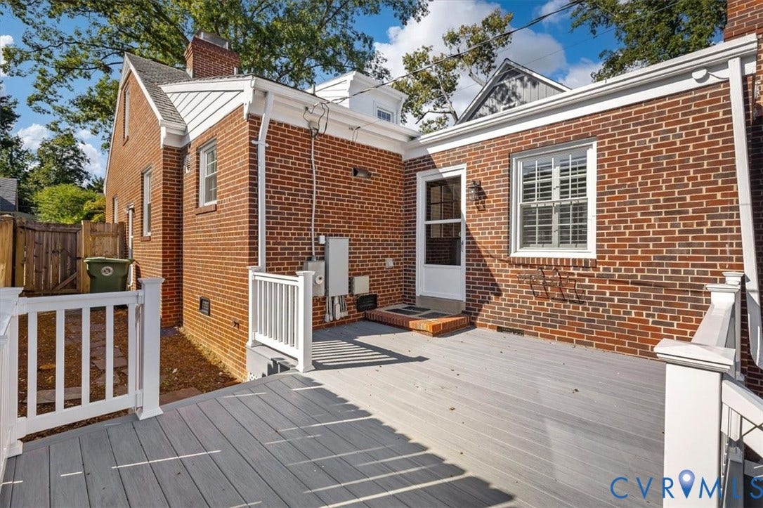 613 Maple Avenue, Near West End, Richmond, VA 23226 Brick exterior featuring a composite deck with white railings, a white screen door, and a multi-pane window with interior shutters