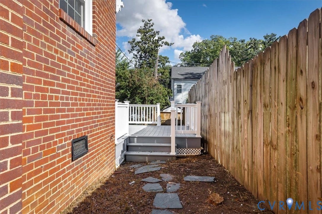 613 Maple Avenue, Near West End, Richmond, VA 23226 Brick exterior with a window and a deck featuring white railings and gray steps